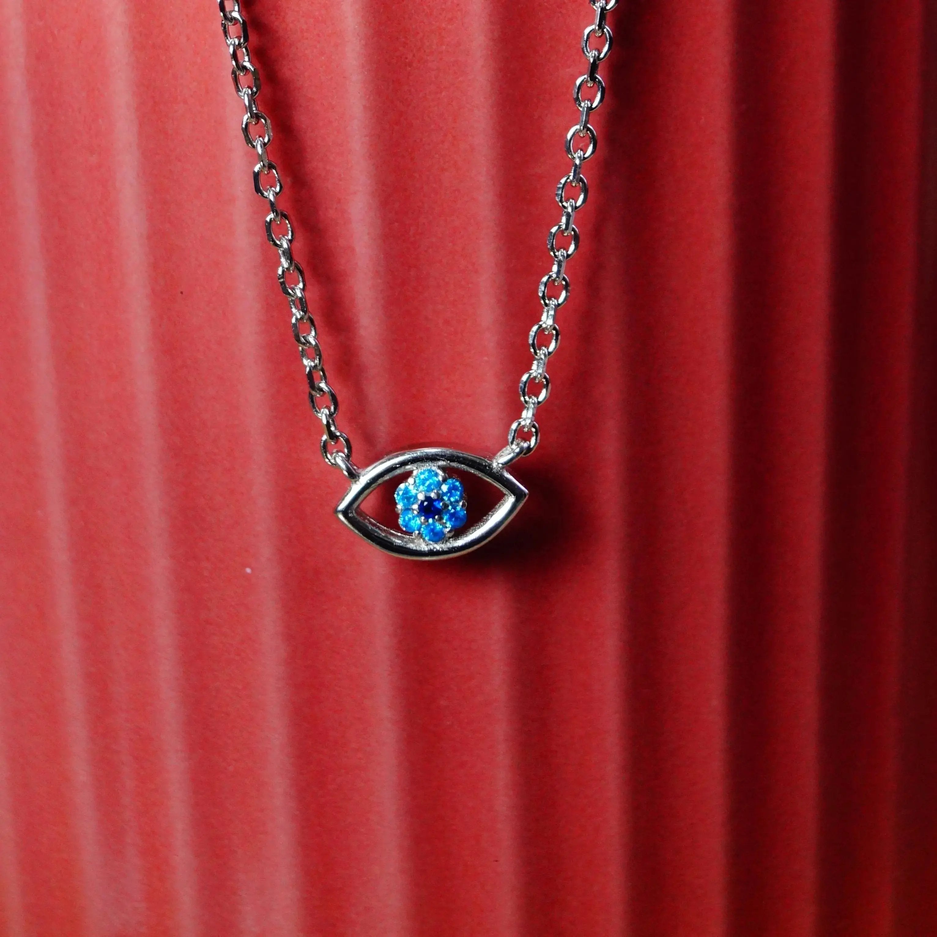 Necklace with a blue gemstone on a red textured surface