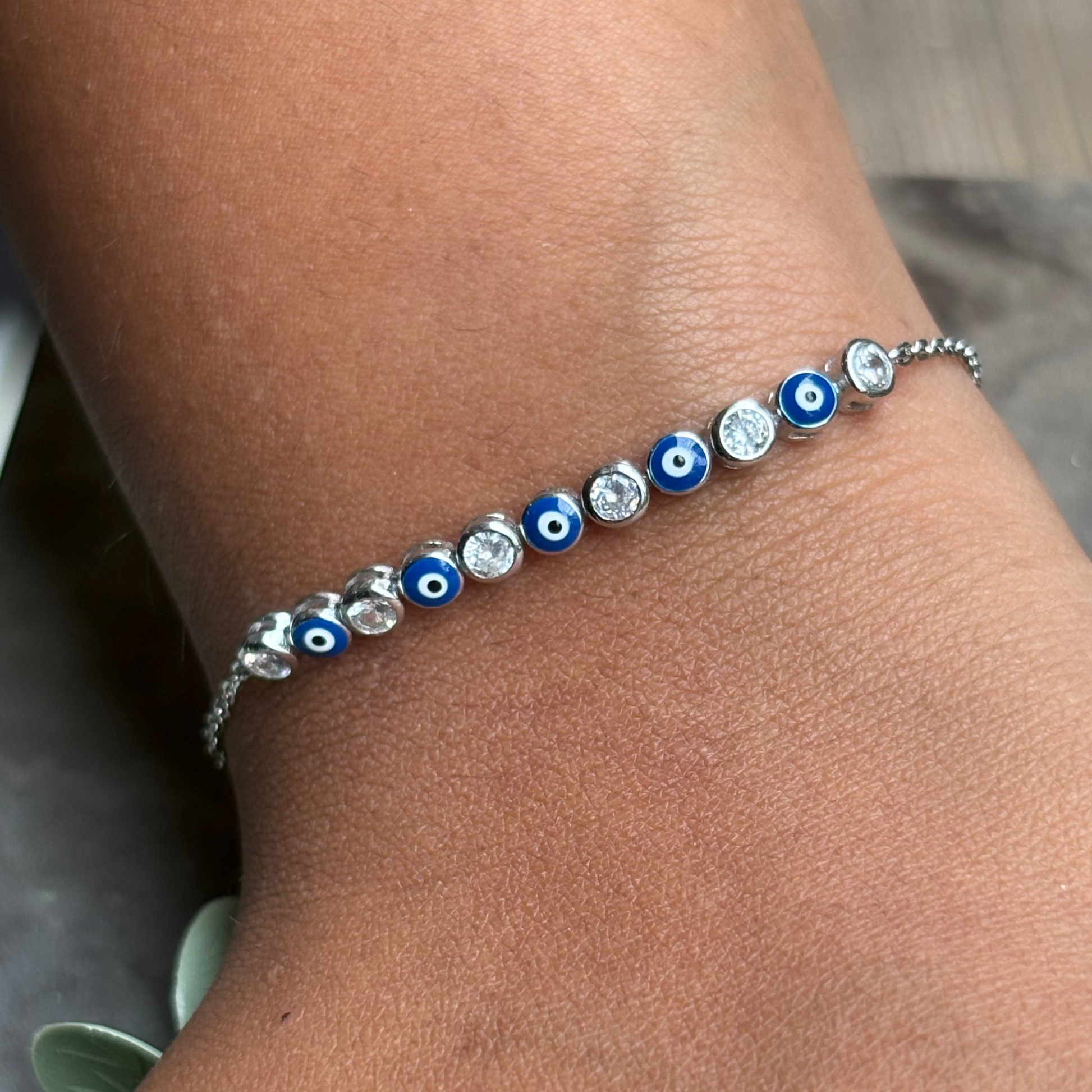 Bracelet with blue and silver beads on a wrist against a neutral background